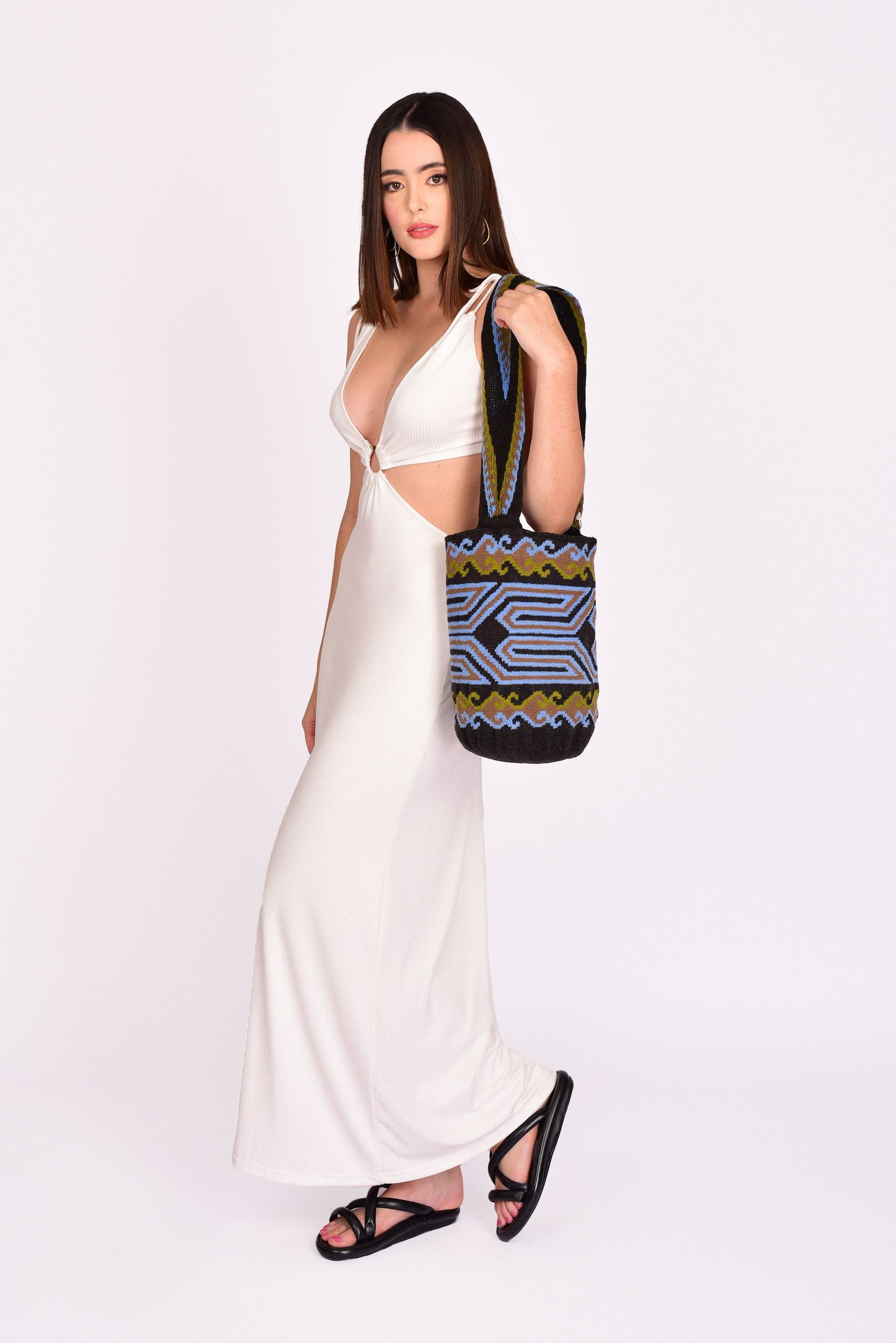 Mochila Wayuu artesanal con diseño geométrico en colores negro, azul y verde, con correa tejida a mano.