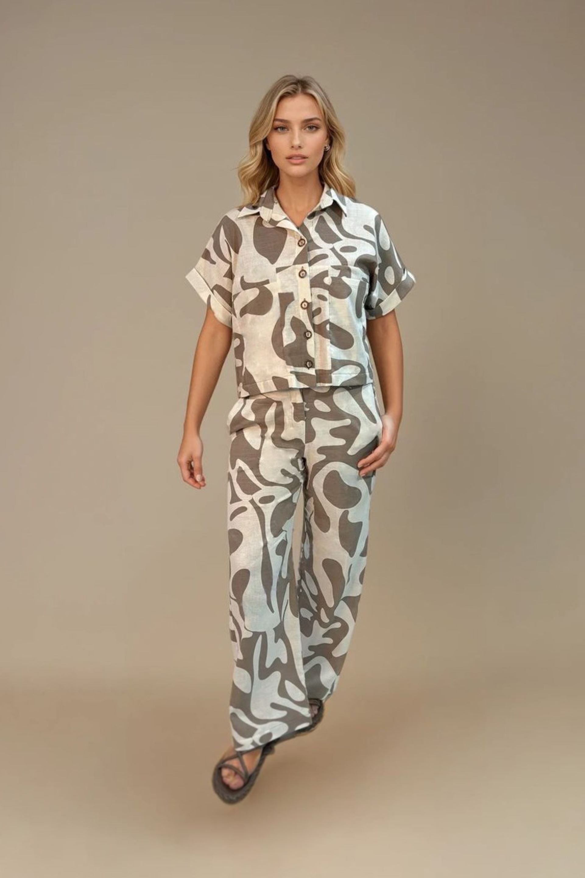Conjunto estampado en tonos tierra y beige, confeccionado en Colombia. Compuesto por una camisa de manga corta con botones frontales y un pantalón de pierna ancha y tiro alto. Un diseño fresco y sofisticado, ideal para un estilo relajado con un toque elegante.