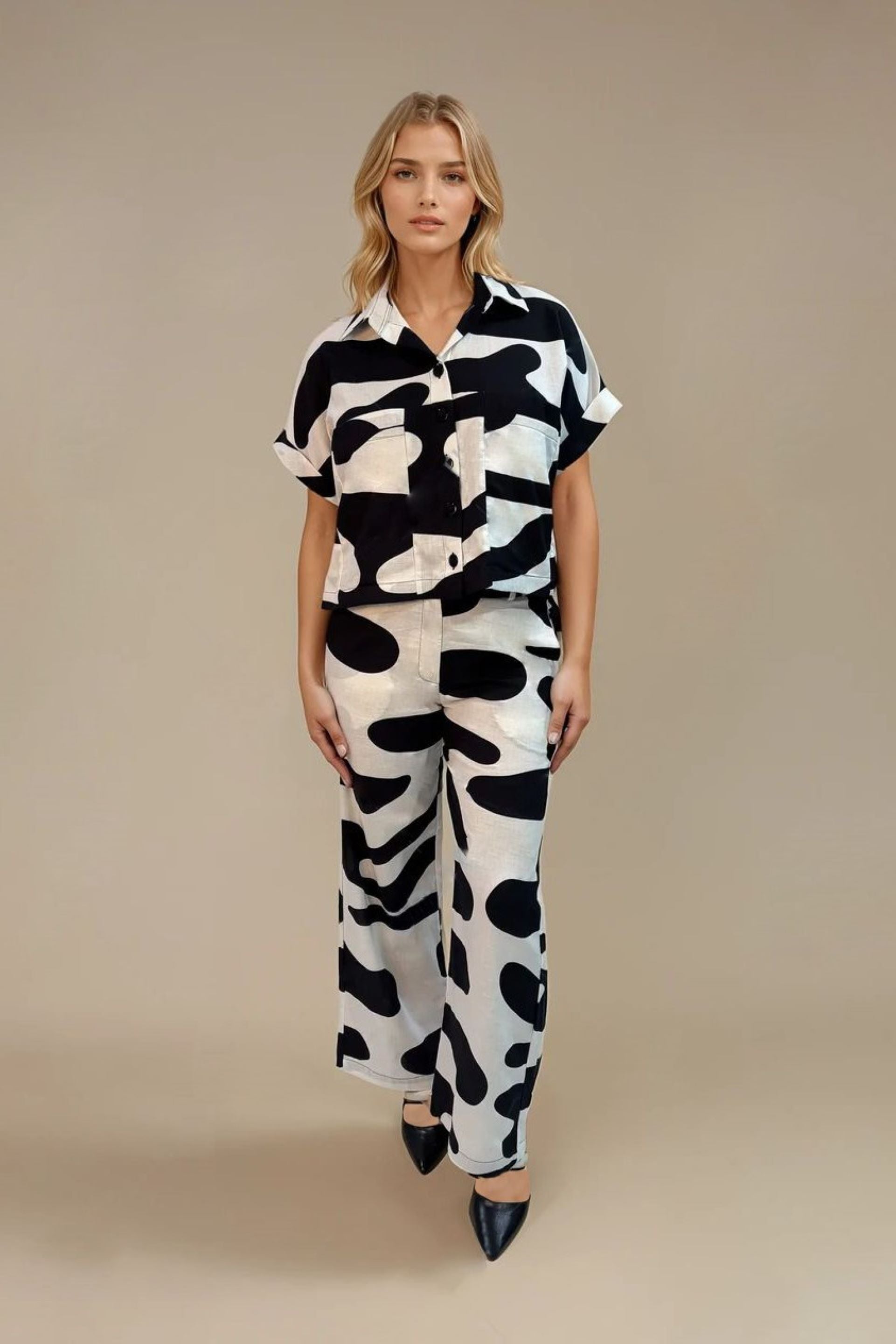 Conjunto estampado en blanco y negro, confeccionado en Colombia. Incluye una camisa de manga corta con botones frontales y un pantalón de pierna ancha de tiro alto. Un diseño sofisticado y moderno, ideal para un look elegante y vanguardista.