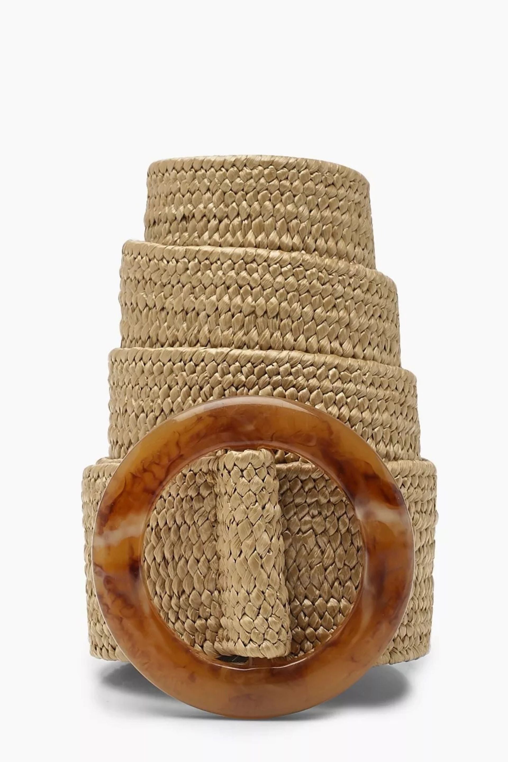 Cinturón tejido en fibra natural con hebilla circular en tonos marrón y beige. Diseño artesanal, versátil y ajustable, ideal para complementar looks casuales o bohemios con un toque elegante y natural.