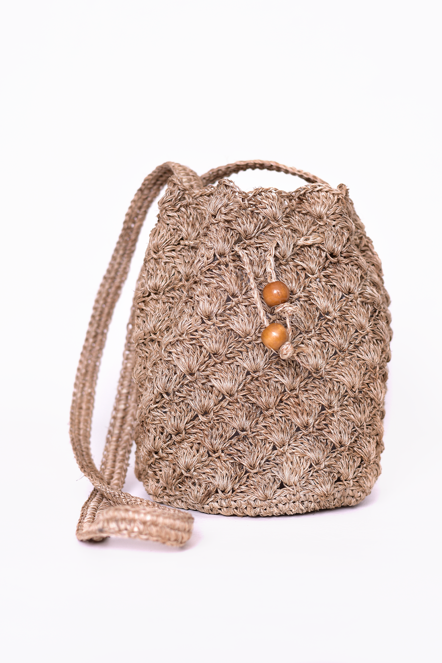 Mochila artesanal tejida a mano con hilo natural, perfecta para complementar tu estilo casual y bohemio. Confeccionada por manos de artesanas colombianas, con un cierre de cordón decorado con cuentas de madera. ¡Compra online en Micerino y lleva lo mejor de la moda colombiana a tu guardarropa!