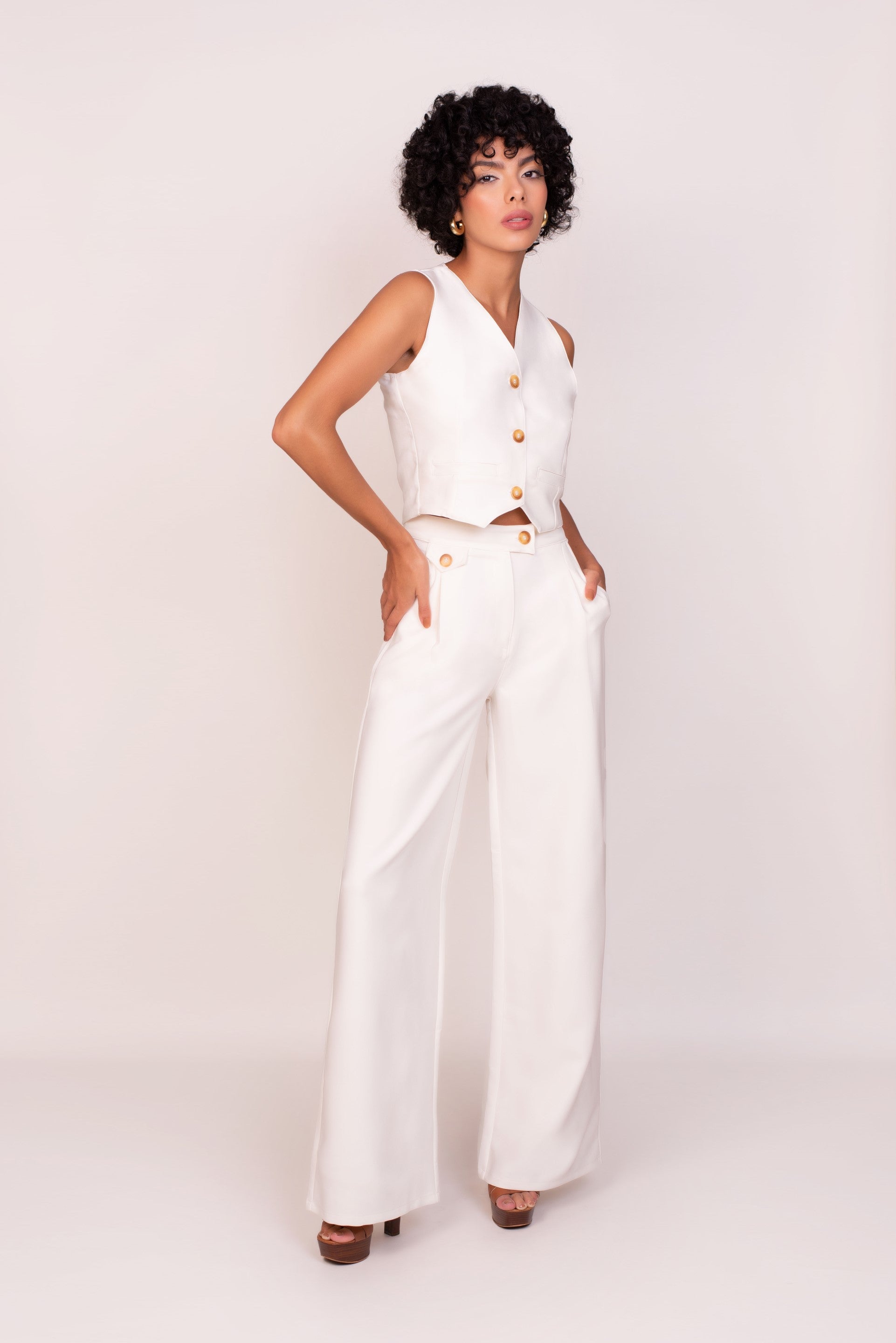 Conjunto blanco, confeccionado en Colombia, con top de botones y pantalones de pierna ancha, ideal para un look fresco y elegante. Esta pieza única de moda colombiana ofrece versatilidad y comodidad. ¡Compra online en Micerino y luce radiante con estilo! Confeccionado en tela ligera noche de viena.