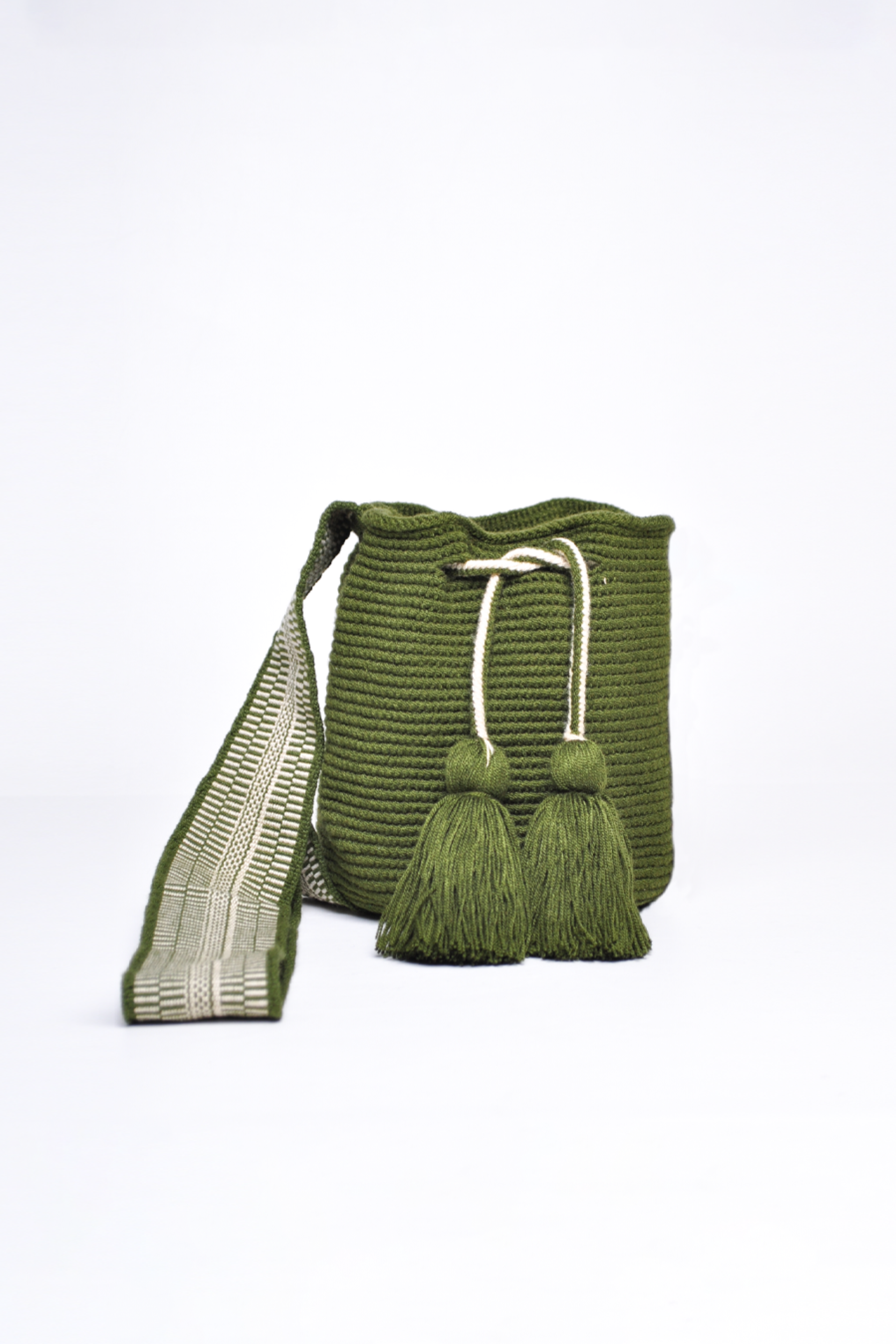 Mochila Wayuu artesanal tejida a mano en color verde, con borlas decorativas y asa larga. Diseñada con un patrón tradicional, fabricada por artesanas indígenas de la comunidad Wayuu en Colombia. Ideal para quienes buscan un accesorio único. ¡Compra online en Micerino y luce lo mejor de la moda hecha en Colombia!