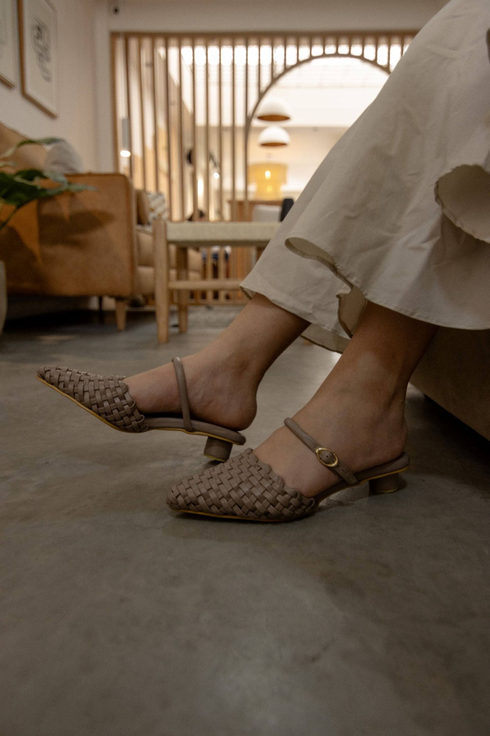 Zapatos tipo mule en tono nude con diseño tejido y correa ajustable en el tobillo con mini tacón forrado de 2.5cm, adelante cerradas en punta, con hebilla, Fabricados en Colombia con cuero de bovino color arena., combinan elegancia y comodidad con un toque artesanal. Perfectos para un look sofisticado y versátil.