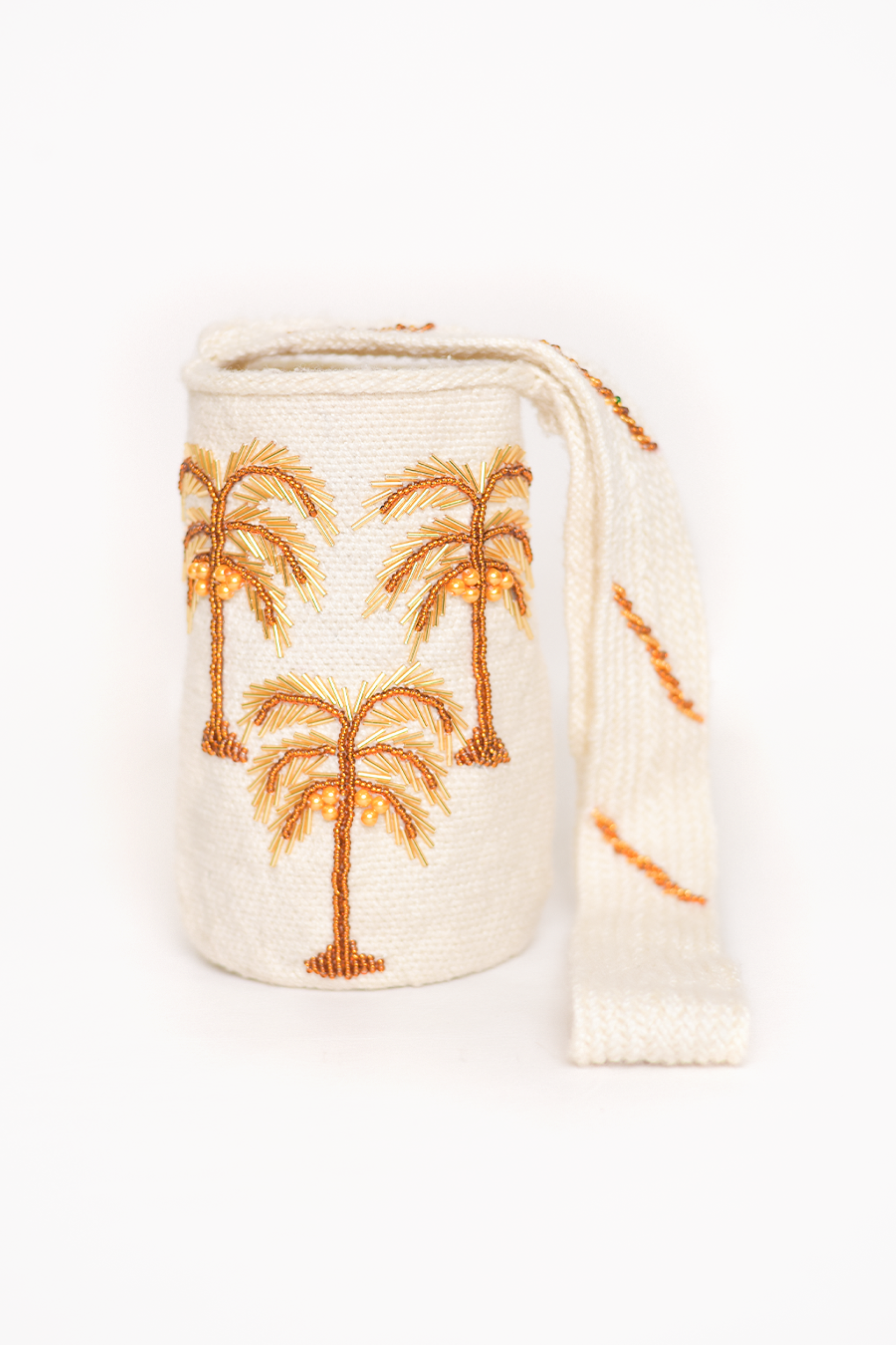 Mochila Kankuama hecha a mano, con bordado detallado de palmeras en colores cálidos que evocan la esencia tropical. La mochila, confeccionada en material de alta calidad, presenta una correa tejida que resalta el trabajo artesanal de la comunidad kankuama en Colombia. Un accesorio único y auténtico de moda colombiana.