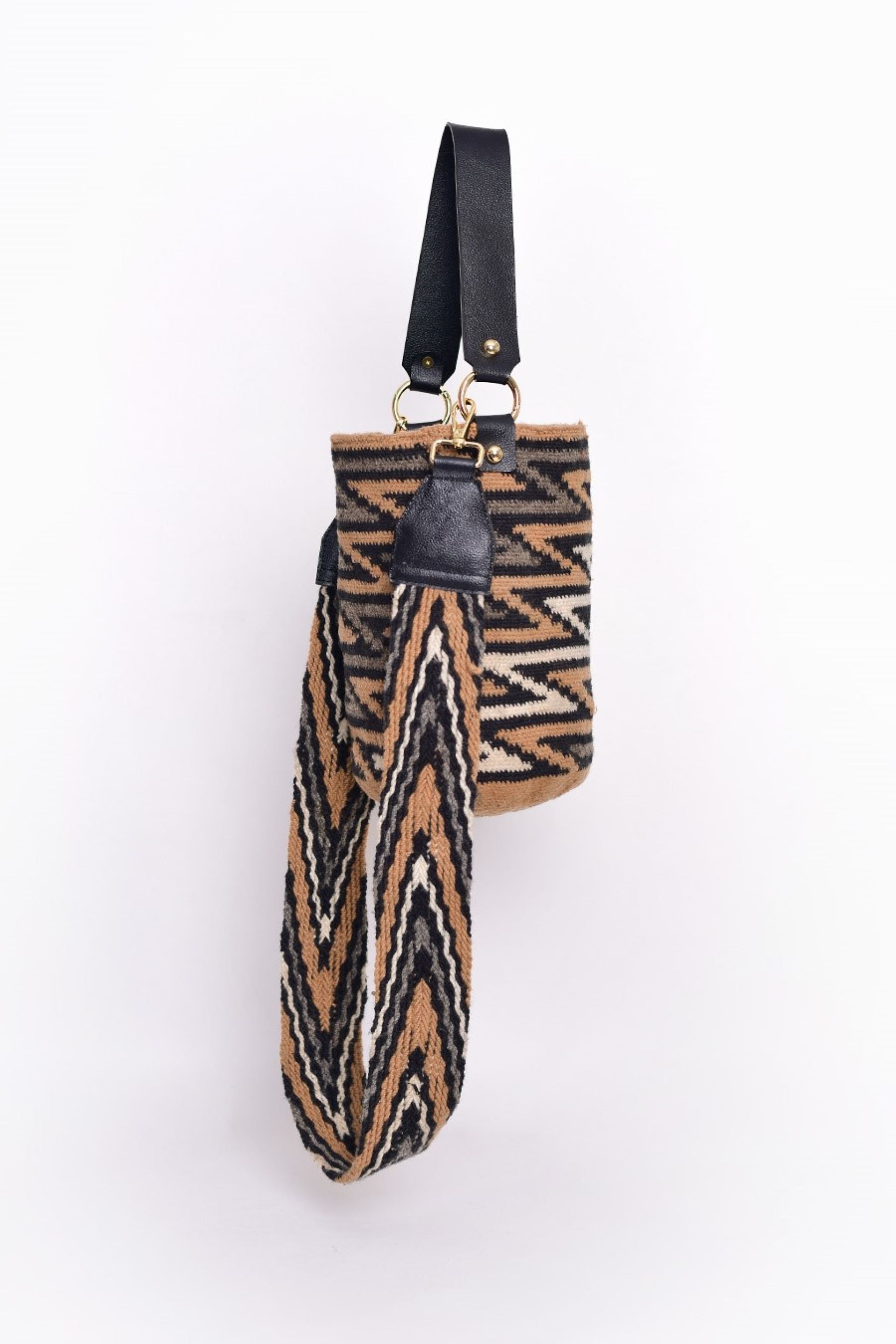 La mochila kankuama con patrón geométrico de zigzag en tonos marrón, beige y negro, confeccionado en Colombia. Este bolso, realizado a mano, fusiona el arte tradicional de la moda colombiana con un diseño moderno y elegante. Ideal para cualquier ocasión. ¡Compra online en Micerino y disfruta de un accesorio único!