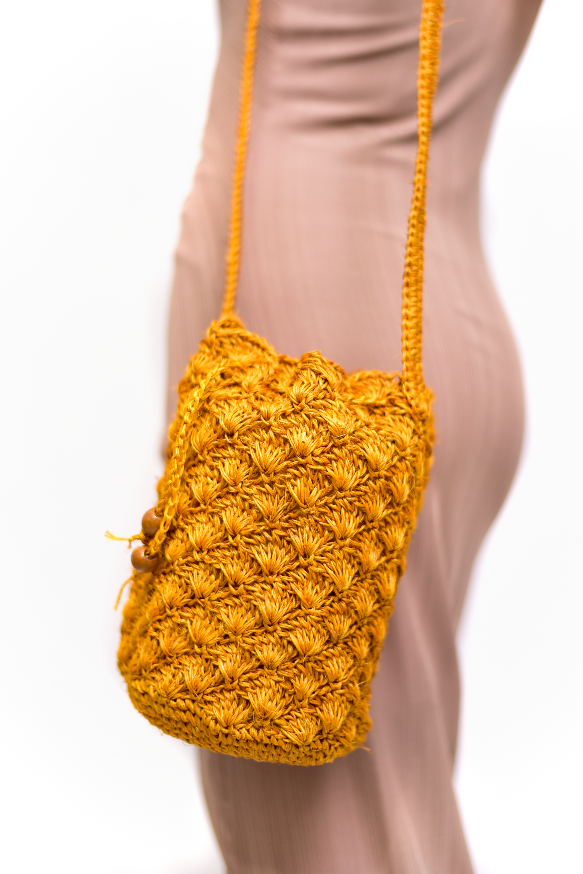 Mochila artesanal tejida a mano con hilo natural, perfecta para complementar tu estilo casual y bohemio. Confeccionada por manos de artesanas colombianas, con un cierre de cordón decorado con cuentas de madera. ¡Compra online en Micerino y lleva lo mejor de la moda colombiana a tu guardarropa!