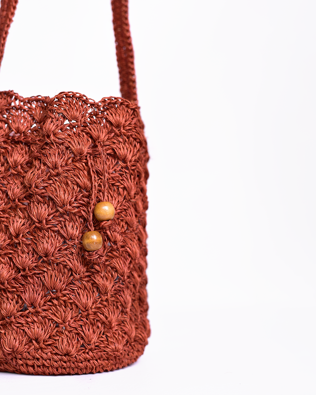 Mochila artesanal tejida a mano con hilo natural, perfecta para complementar tu estilo casual y bohemio. Confeccionada por manos de artesanas colombianas, con un cierre de cordón decorado con cuentas de madera. ¡Compra online en Micerino y lleva lo mejor de la moda colombiana a tu guardarropa!