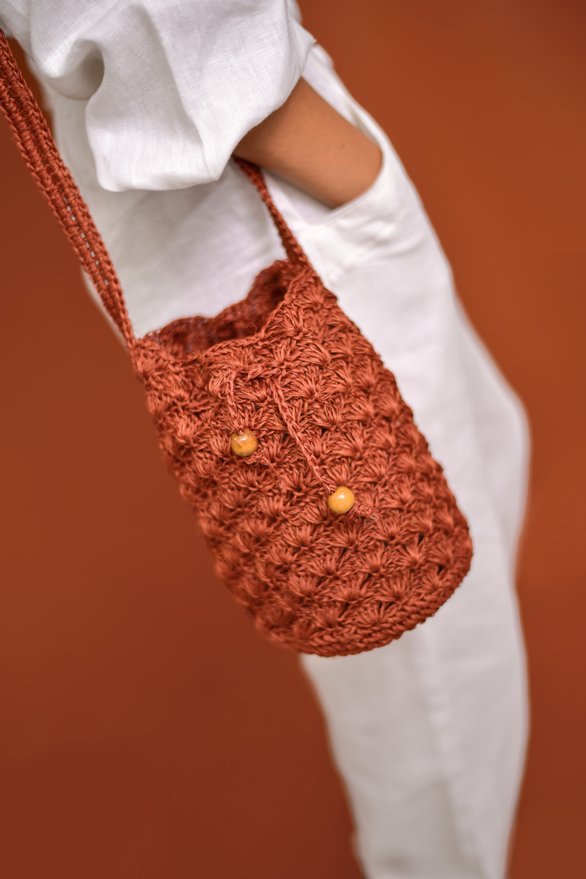 Mochila artesanal tejida a mano con hilo natural, perfecta para complementar tu estilo casual y bohemio. Confeccionada por manos de artesanas colombianas, con un cierre de cordón decorado con cuentas de madera. ¡Compra online en Micerino y lleva lo mejor de la moda colombiana a tu guardarropa!