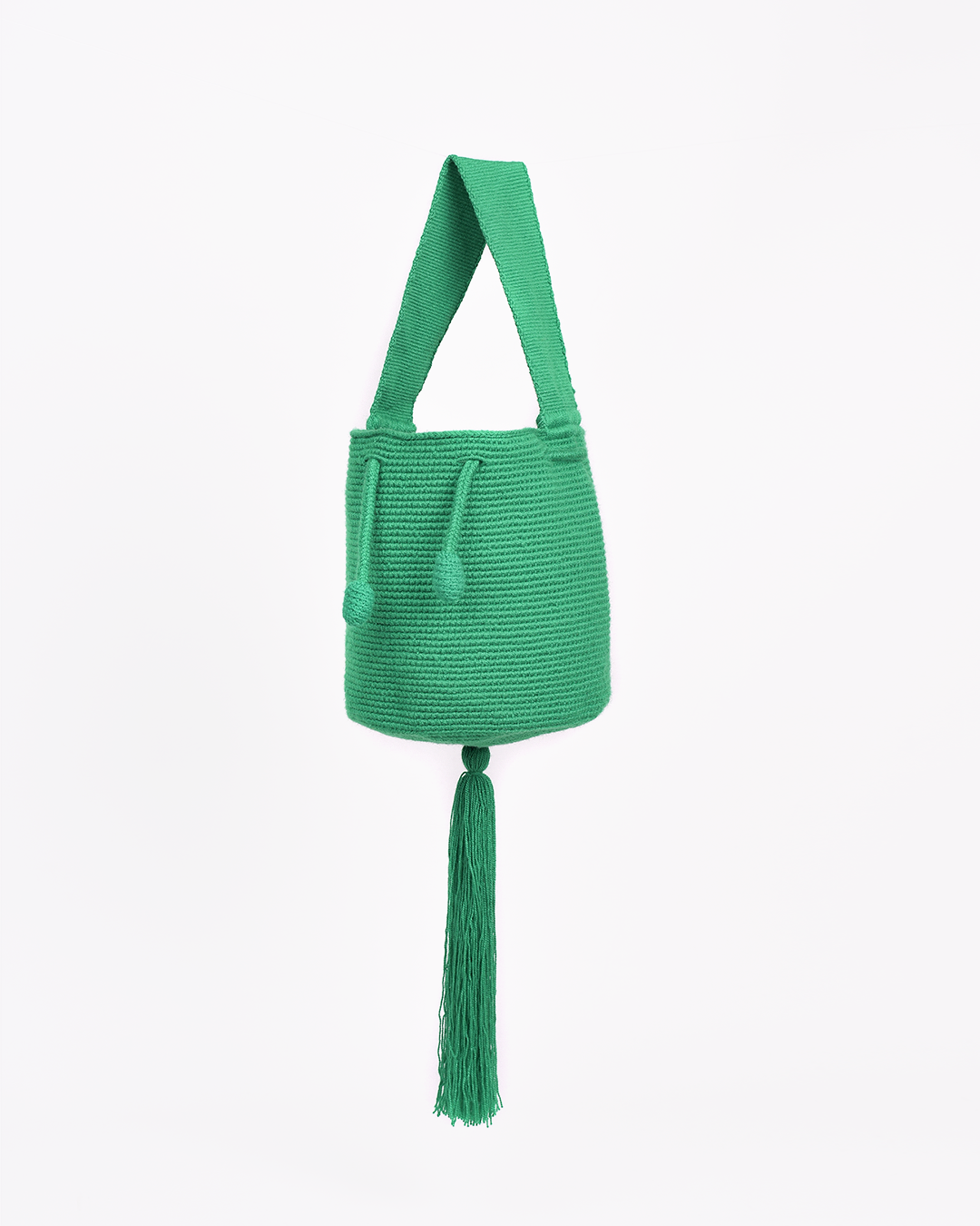 Mini mochila Wayuu artesanal, tejida a mano con hilo unicolor verde, con un colgante decorativo. Cuenta con una cargadera corta y un cordón ajustable. Hecha por artesanas de la comunidad Wayuu, reflejando la autenticidad de la moda colombiana.
