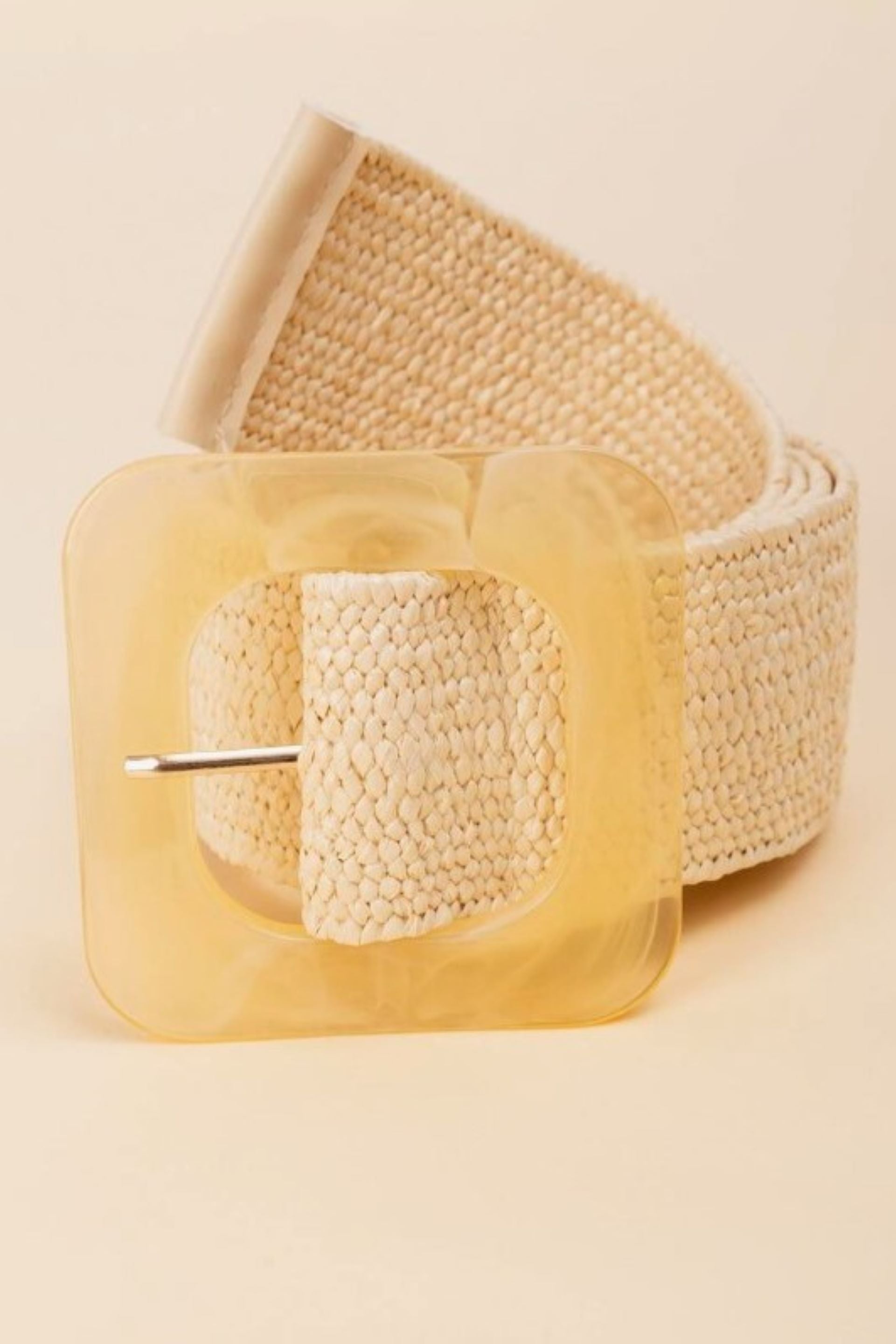Cinturón tejido en color natural con hebilla cuadrada de resina. Diseño versátil y ajustable, ideal para complementar outfits casuales o elegantes. ¡Compra online en Micerino!