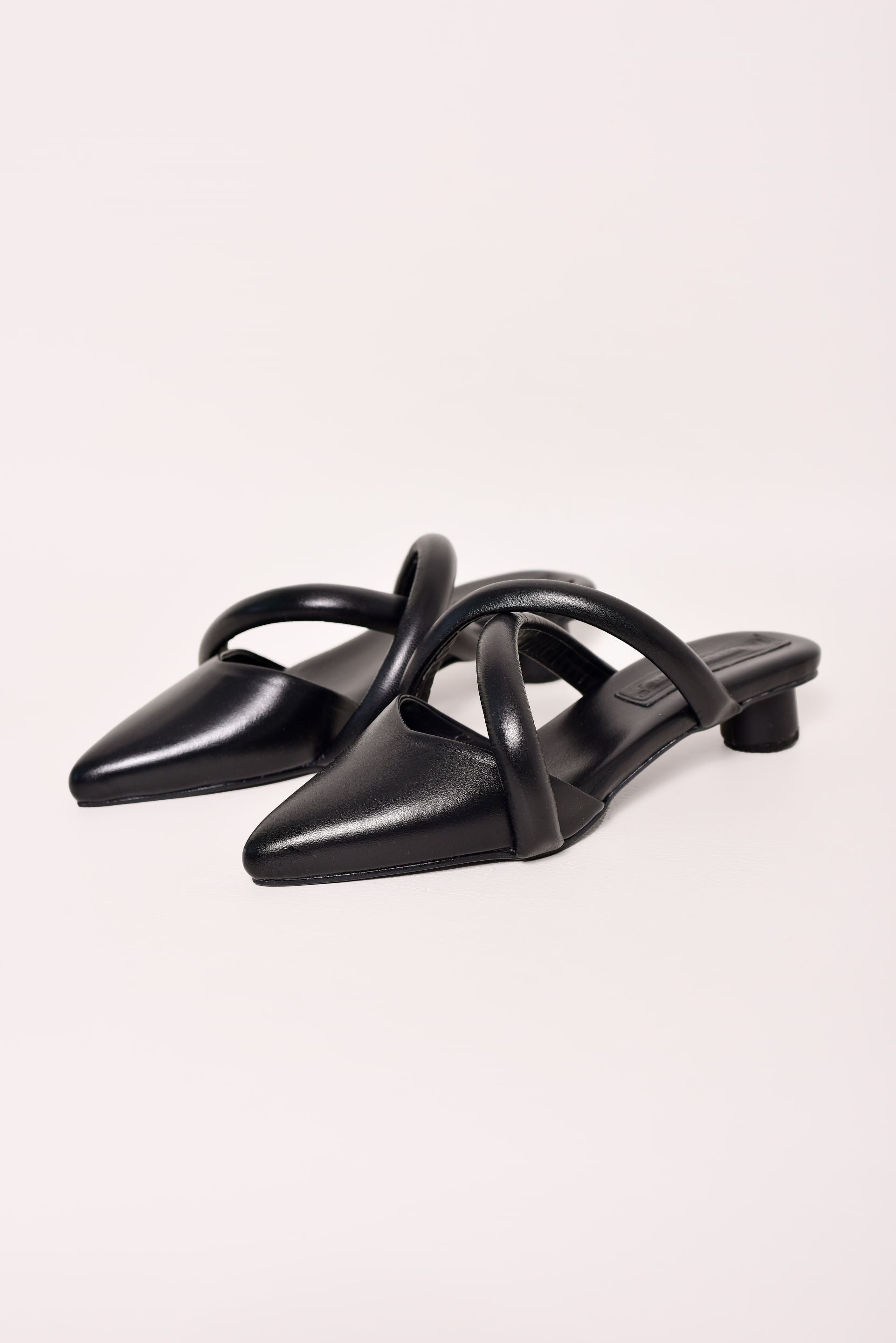 Sandalias mule de tacón bajo en cuero negro con diseño de tiras entrecruzadas. Un calzado elegante y minimalista, ideal para un look sofisticado y versátil. tacon 2.5cm