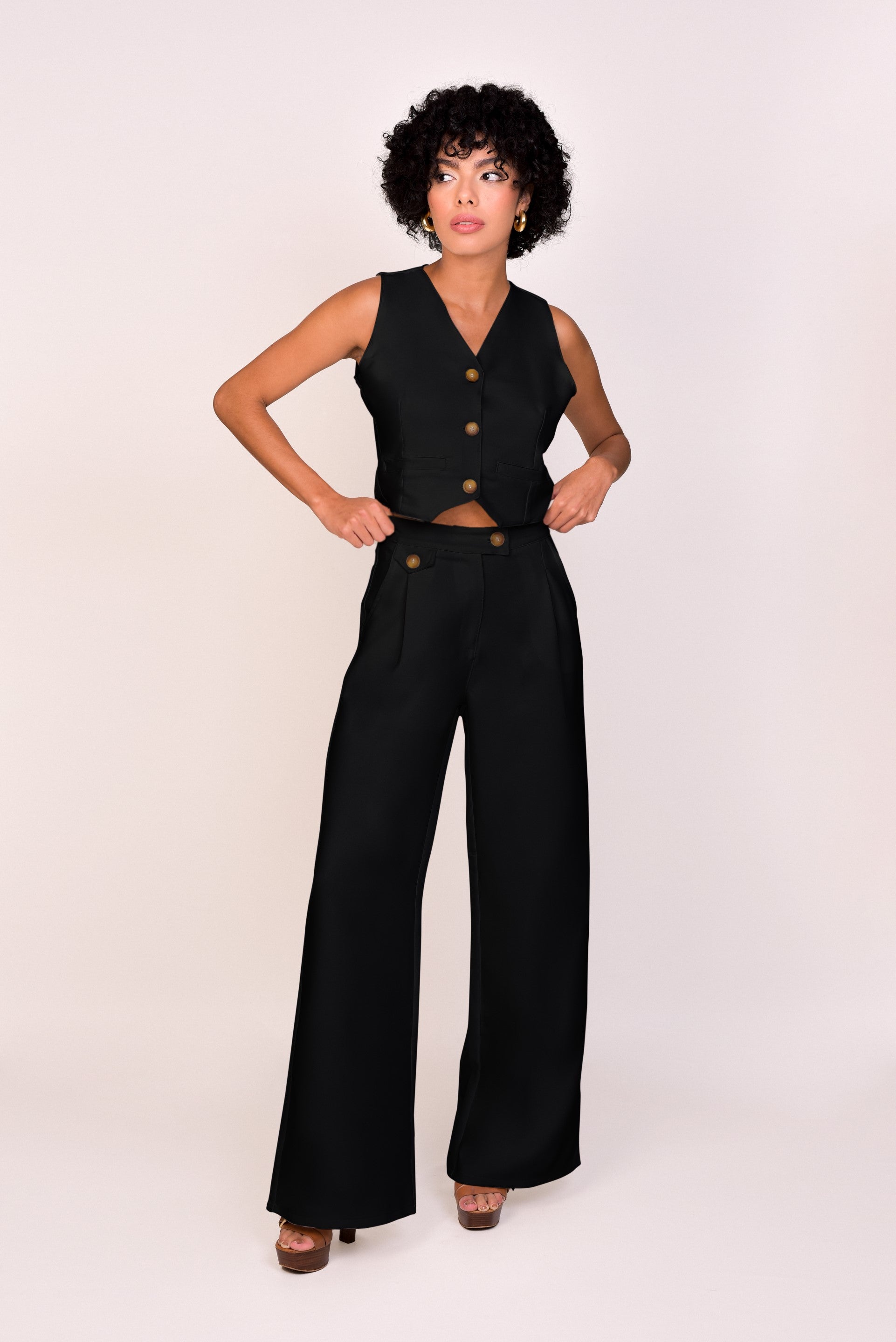 Conjunto negro, confeccionado en Colombia, con top de botones y pantalones de pierna ancha, ideal para un look fresco y elegante. Esta pieza única de moda colombiana ofrece versatilidad y comodidad. ¡Compra online en Micerino y luce radiante con estilo! Confeccionado en tela ligera noche de viena,