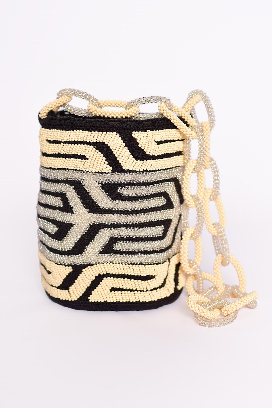 Mochila artesanal Wayuu con diseño geométrico en mostacillas de tonos negro, dorado y plateado. Hecha a mano con cuentas y cadenas brillantes, ideal para añadir un toque único y elegante a tu look. Producto 100% confeccionado en Colombia, una opción perfecta para quienes buscan moda colombiana auténtica