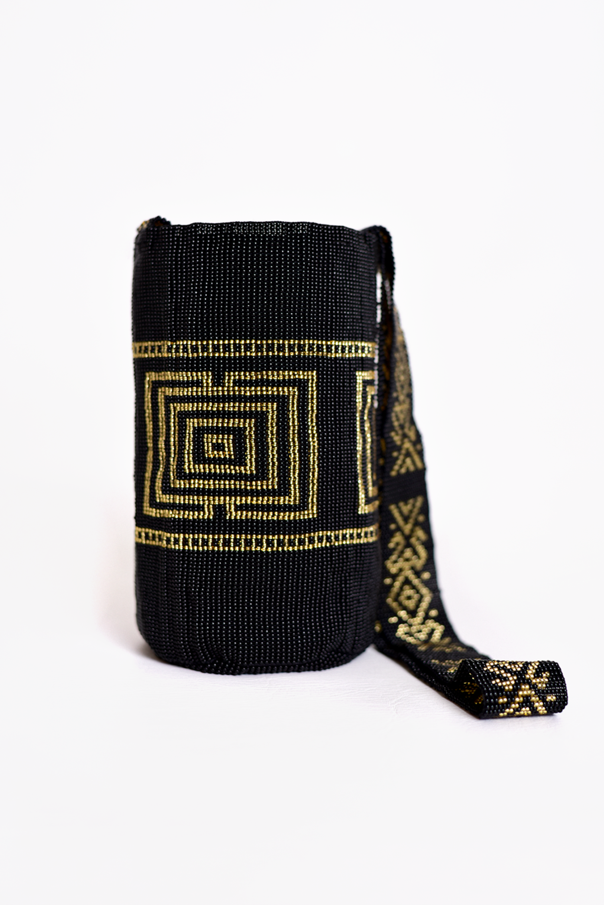 Mochila artesanal en color negro con detalles dorados, tejida a mano mostacilla. Perfecta para quienes buscan moda colombiana de calidad, ideal para cualquier ocasión. ¡Compra online en Micerino y luce lo mejor de la cultura!