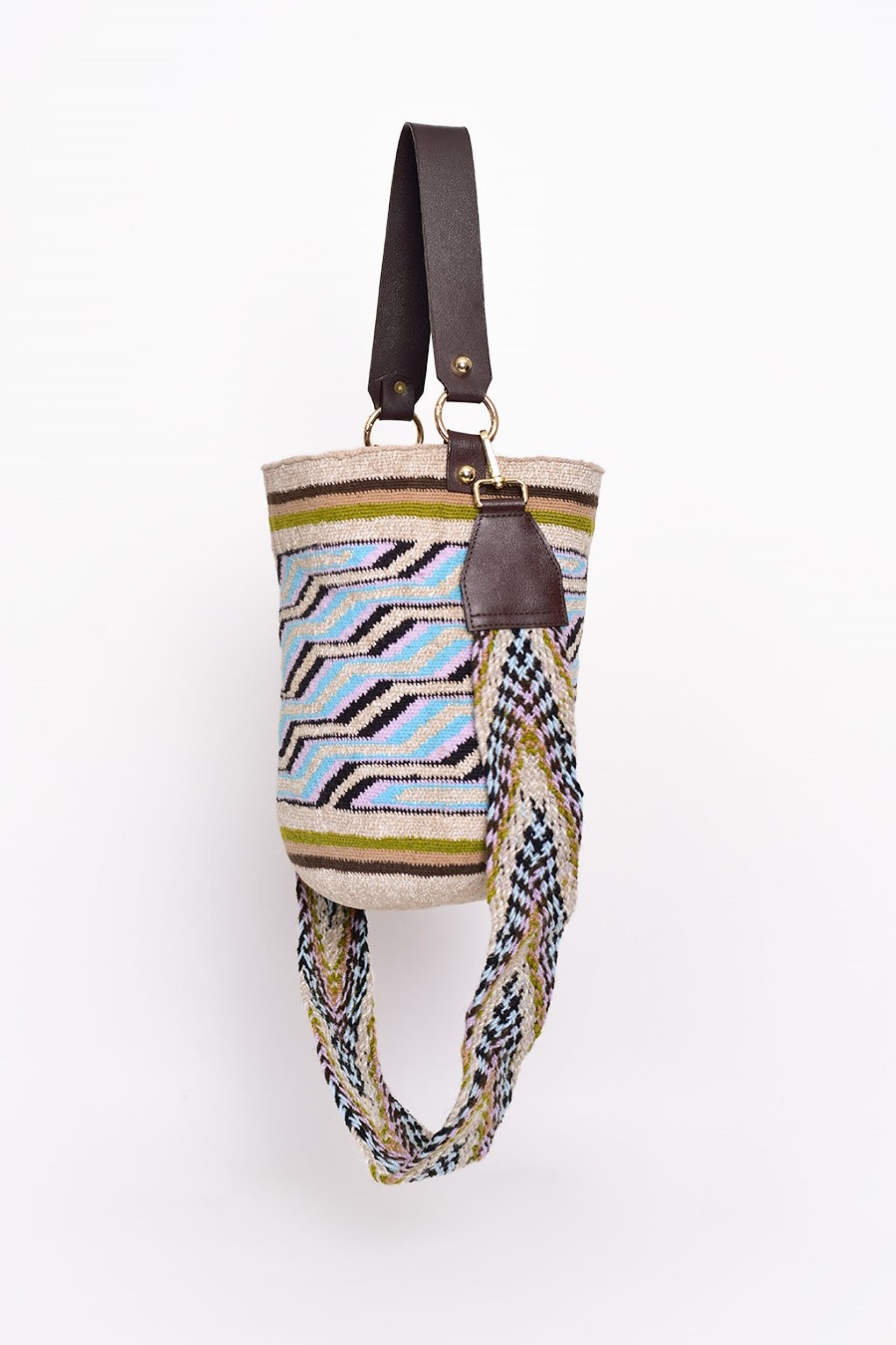La mochila kankuama cartesanal con un diseño vibrante en tonos azules, verdes y morados, complementado con asas de cuero marrón. Hecho a mano por artesanos colombianos, este bolso fusiona tradición y estilo contemporáneo. ¡Compra online en Micerino y lleva la moda colombiana confeccionada en Colombia directamente a tu hogar!