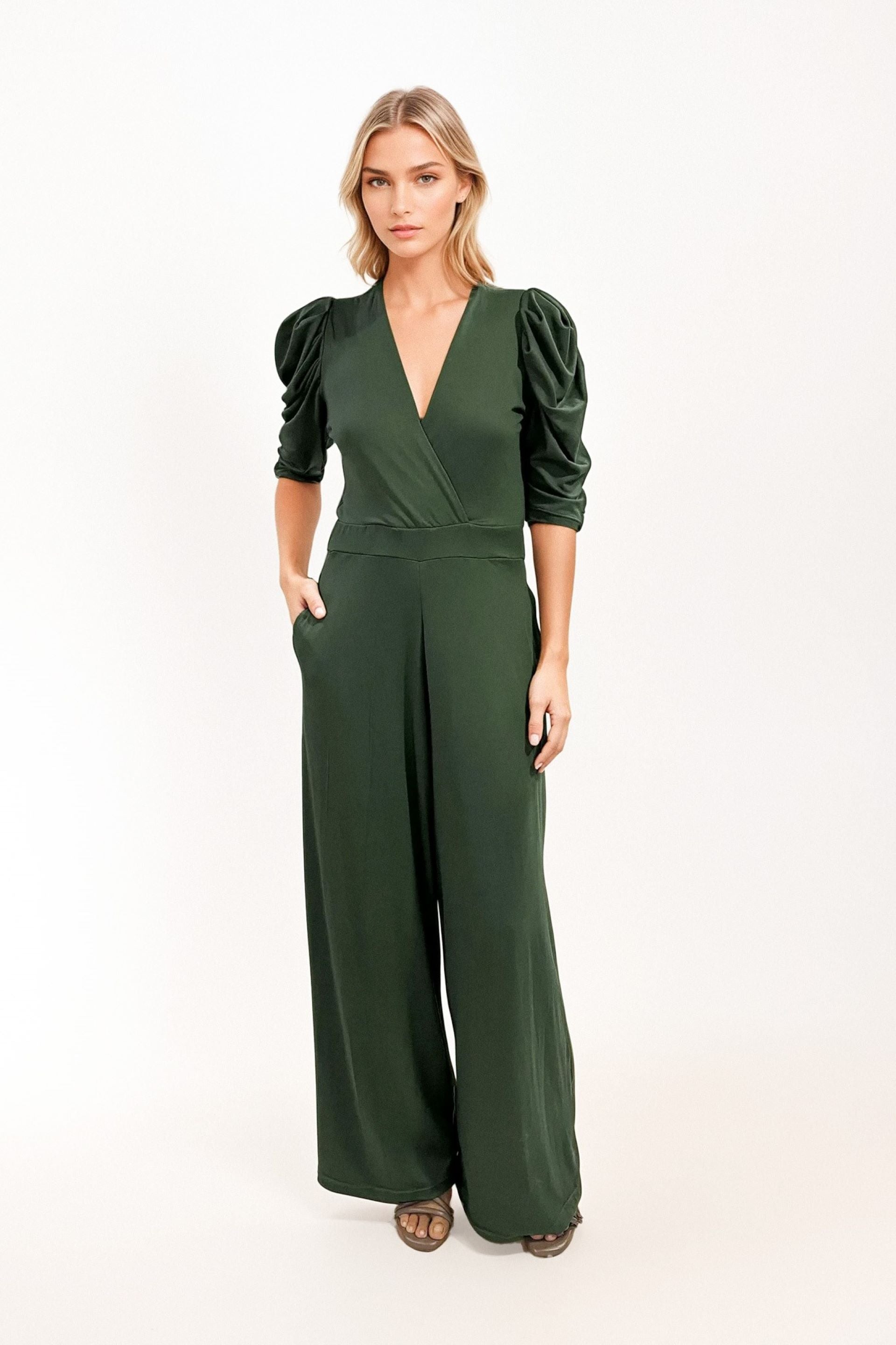 Jumpsuit verde con escote en V y mangas abullonadas. Diseño elegante y sofisticado con ajuste en la cintura y pantalón de bota ancha. Perfecto para eventos formales o un look chic de día. ¡Compra online en Micerino!