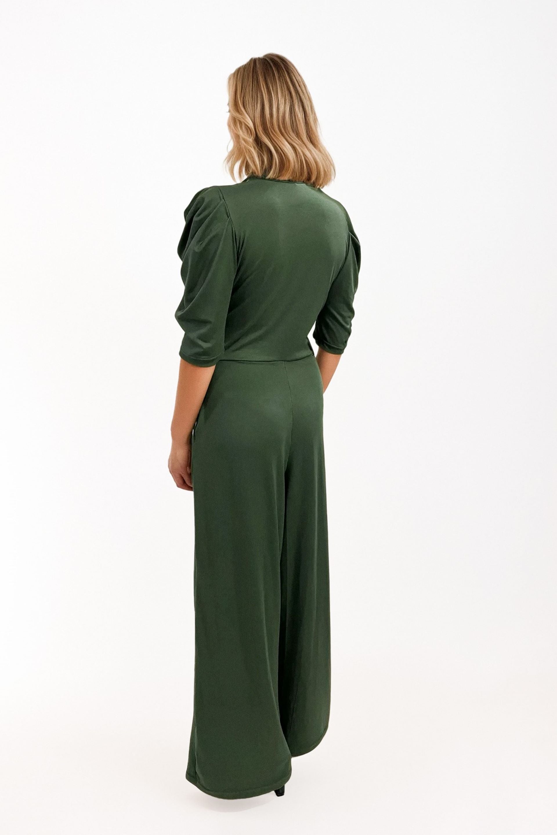 Jumpsuit verde con escote en V y mangas abullonadas. Diseño elegante y sofisticado con ajuste en la cintura y pantalón de bota ancha. Perfecto para eventos formales o un look chic de día. ¡Compra online en Micerino!